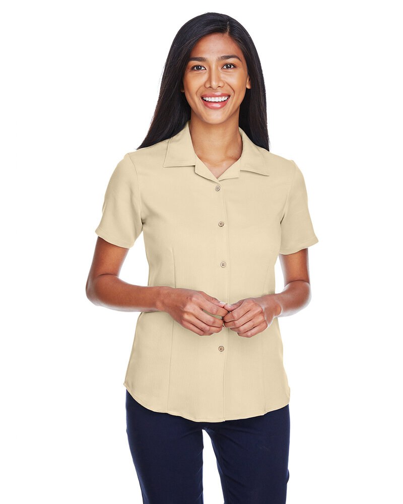 A woman models a beige short-sleeved shirt