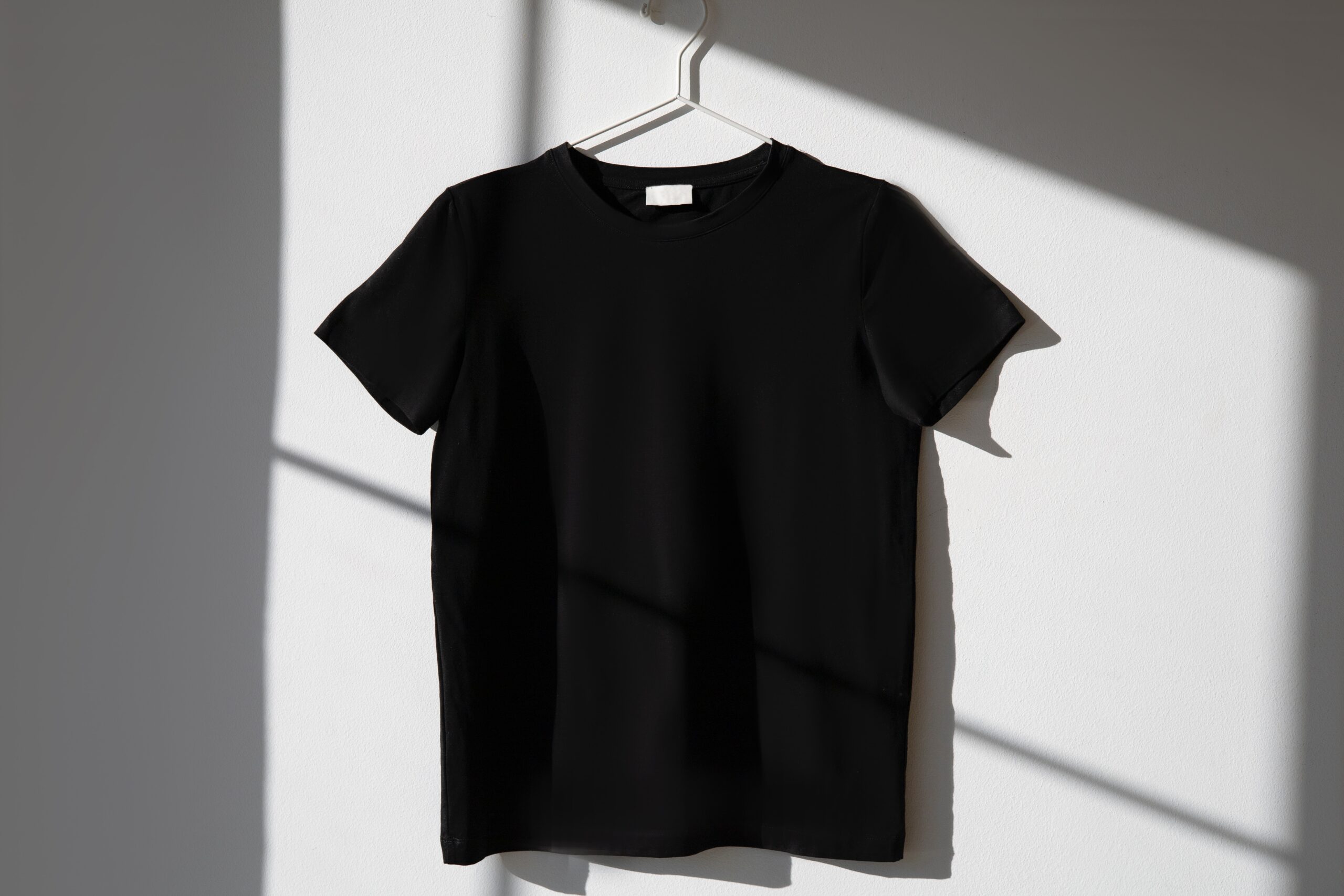 black blank t-shirt hanging on the wall
