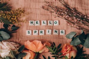 'hello spring' written with cubes surrounded by spring flowers