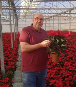 Eudal poses with a red flower, to a backdrop of thousands