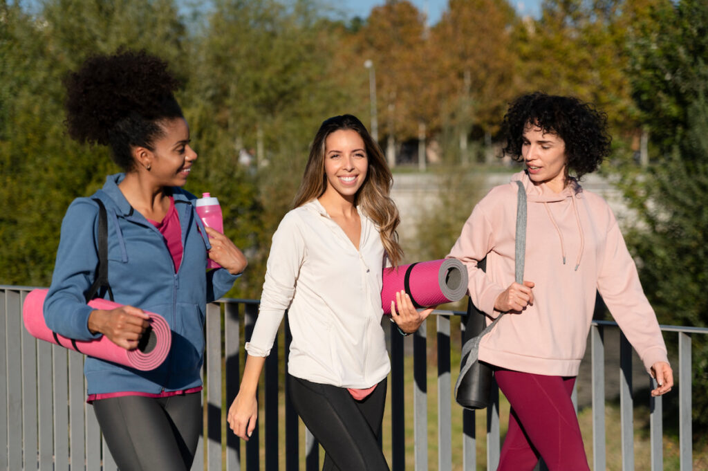 Three women walking in yoga clothes