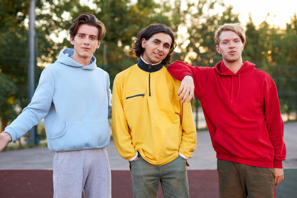 3 teenage boys wearing hoodies or other sweatshirts