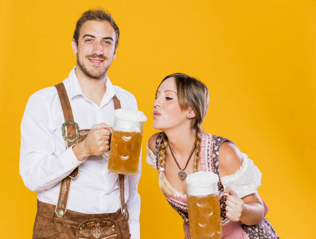 A young couple model lederhosen and a dirndl, the traditional dress of Oktoberfest